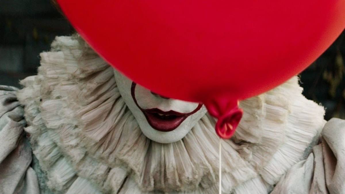 Primer plano de Pennywise el payaso con un globo rojo